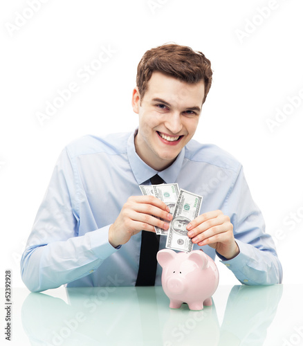 Photo: Man putting money in piggy bank Man putting money in piggy bank