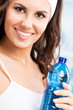 Woman with bottle of water, at fitness club