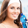 Woman drinking water, at fitness club