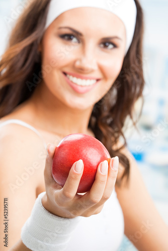 Photo: Woman with apple, at fitness center Woman with apple, at fitness center