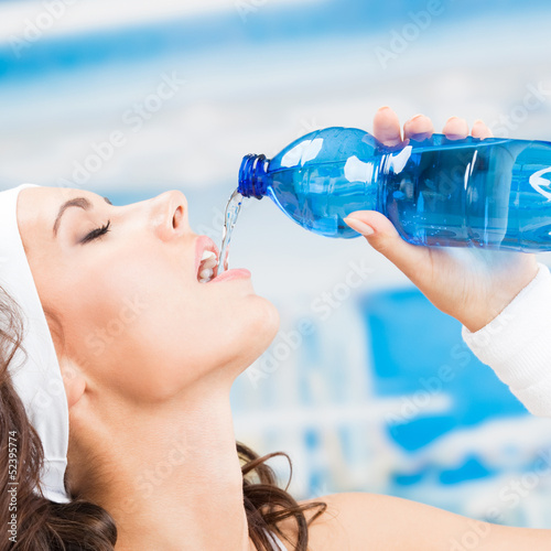 Photo: Woman drinking water, at fitness club Woman drinking water, at fitness club