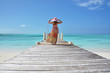 Girl on the wooden jetty looking to the ocean. Exuma, Bahamas