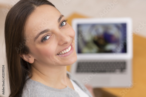 Photo: Woman on sofa with her laptop face camera Woman on sofa with her laptop face camera