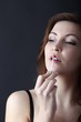 beautiful young woman applying lip gloss