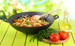 Noodles with vegetables on wok on nature background background
