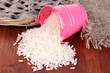 Overturned bucket with grains on wooden background