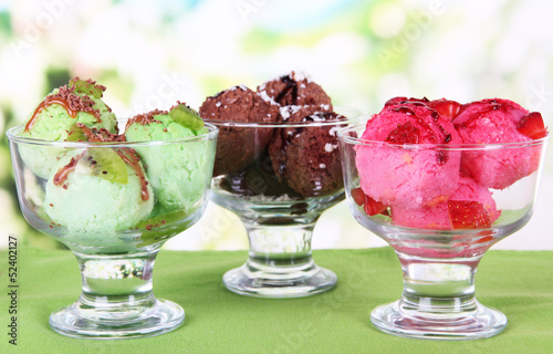 Photo: Delicious ice cream on table on bright background Delicious ice cream on table on bright background
