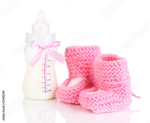 Photo: Bottle for milk formula with booties isolated on white Bottle for milk formula with booties isolated on white