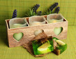 Candles in wooden candlestick, lavender and soap, on green mat