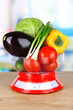 Fresh vegetables in scales on table in kitchen