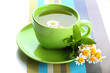 Cup of herbal tea with wild camomiles and mint, isolated