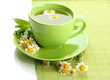 Cup of herbal tea with wild camomiles and mint, isolated