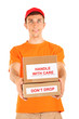 Foto: Young delivery man holding parcels, isolated on white Young delivery man holding parcels, isolated on white