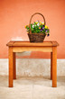 basket with flowers and green leaves on wooden table
