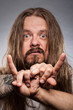 Caucasian Man With Long Hair Giving Devil Horns