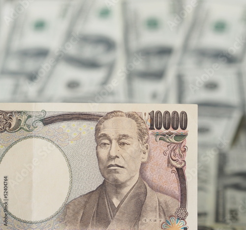 Photo: 10000 Japanese yen note isolated on US dollar note background 10000 Japanese yen note isolated on US dollar note background
