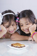 Dos niñas sonrientes ven un apetitoso postre