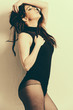 a brunette model wearing a black body and pantyhose