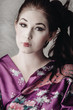 a brunette in traditional asian clothing and makeup