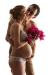 Photo: Portrait of young pregnant couple holding flowers over white Portrait of young pregnant couple holding flowers over white