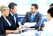 Smiling young man sitting at a business meeting with colleagues