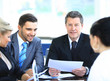 Smiling mature man sitting at a business meeting with colleagues
