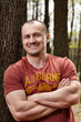 Handsome man leaning on a tree trunk