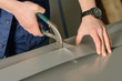 Man cuts metal sheet with a cutter