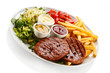 Foto: Grilled steaks, French fries and vegetables Grilled steaks, French fries and vegetables