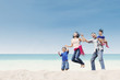 Cheerful family jumping at beach
