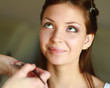 pretty woman applying make up with brush
