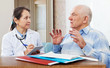  mature doctor talks with sick senior man