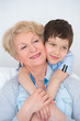 Photo: Lovely little boy with his grandmother having fun and happy mome Lovely little boy with his grandmother having fun and happy mome