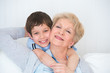 Photo: Lovely little boy with his grandmother having fun and happy mome Lovely little boy with his grandmother having fun and happy mome
