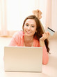Photo: Woman with laptop lying down on the floor Woman with laptop lying down on the floor
