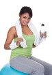 Woman Sitting On Pilates Ball Holding Water Bottle