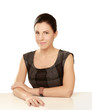 A young woman sitting at the desk, isolated on white background