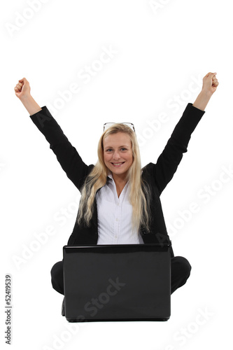 Photo: A victorious businesswoman sitting on the floor. A victorious businesswoman sitting on the floor.