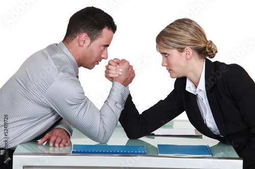Photo: arm wrestling between male and female colleagues arm wrestling between male and female colleagues