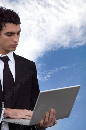 Photo: young business man doing computer outside young business man doing computer outside