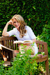 Frau beim Lesen eines Buches im Garten