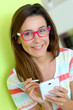 Brunette girl with eyeglasses using smartphone