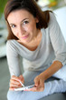 Woman at home relaxing and using smartphone