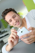 Photo: Smiling man in couch using telephone Smiling man in couch using telephone