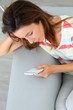 Young woman using smartphone sitting in sofa