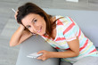 Young woman using smartphone sitting in sofa