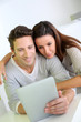Cheerful couple websurfing on internet with tablet