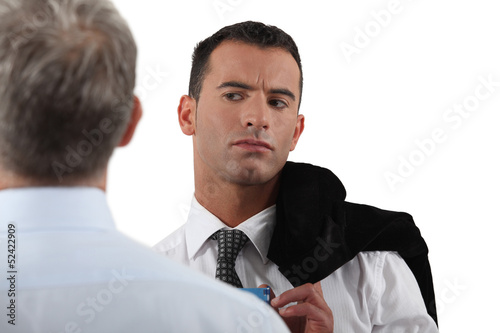 Photo: Man looking suspiciously at his colleague Man looking suspiciously at his colleague
