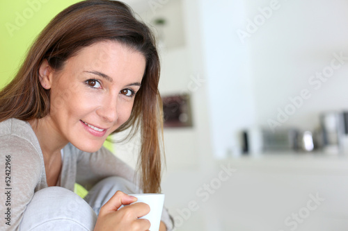 Photo: Beautiful brunette girl drinking coffee Beautiful brunette girl drinking coffee