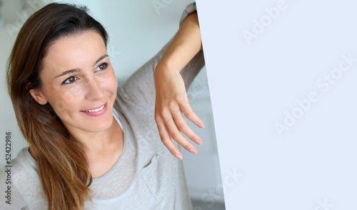 Photo: Relaxed young woman standing at home Relaxed young woman standing at home